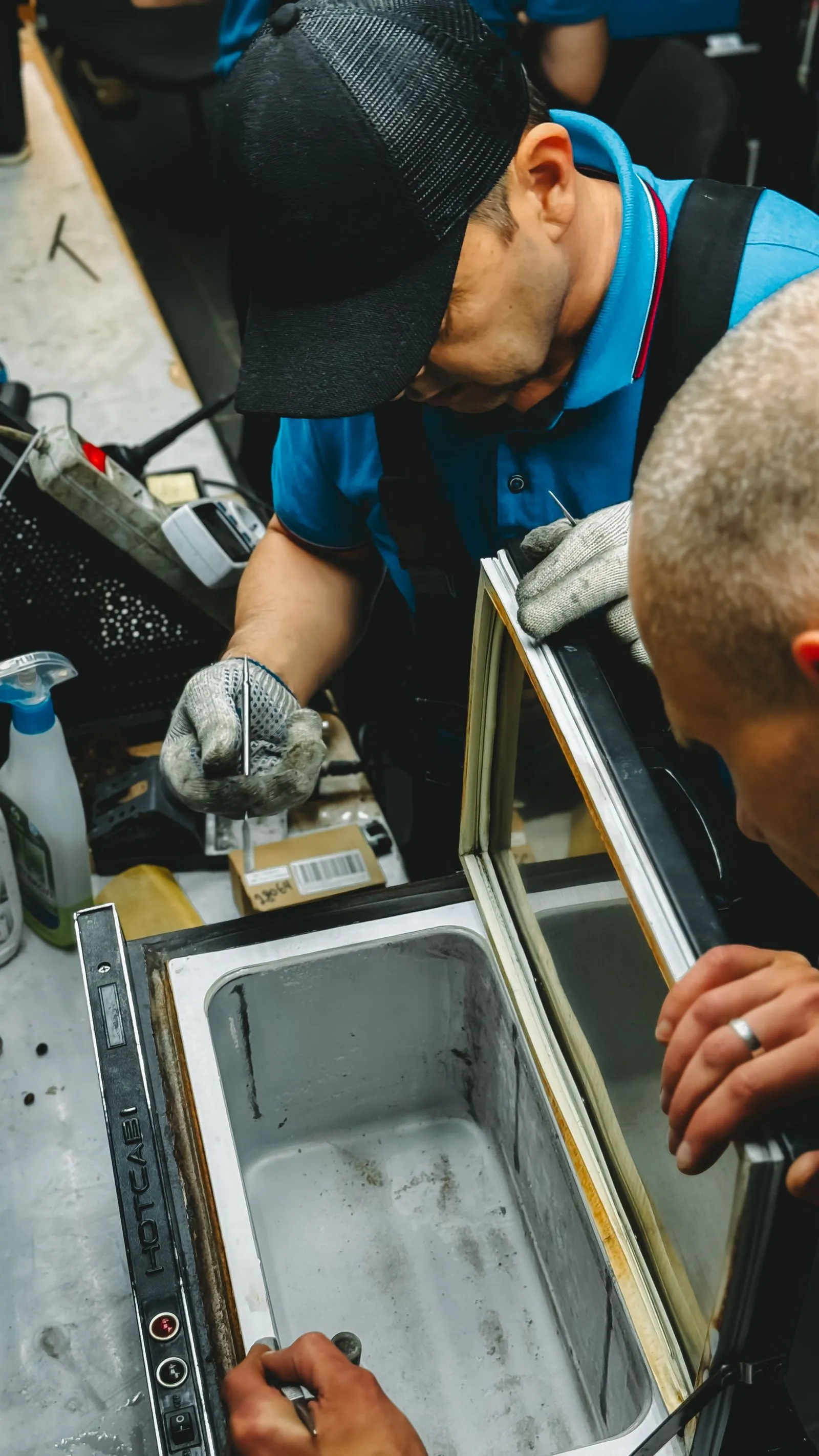 Técnicos reparando una nevera Mabe